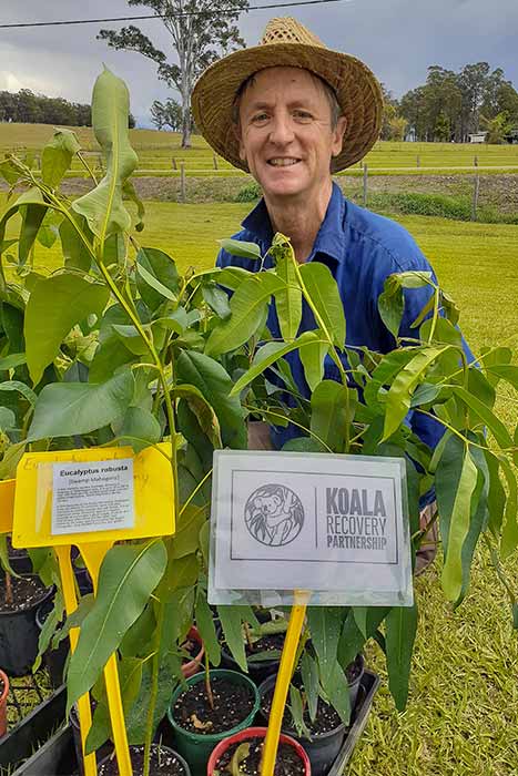 Andy Vinter Standing Behind Tree Saplings For The Koala Project