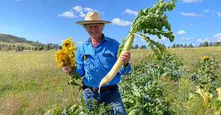 Martin Royds holding produce in a paddock
